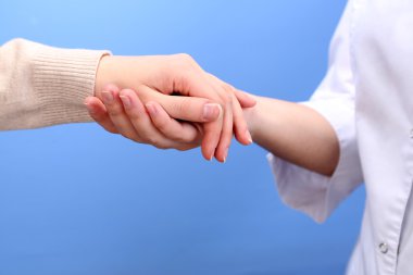açık renkli hastanın elini tutarak tıp doktoru