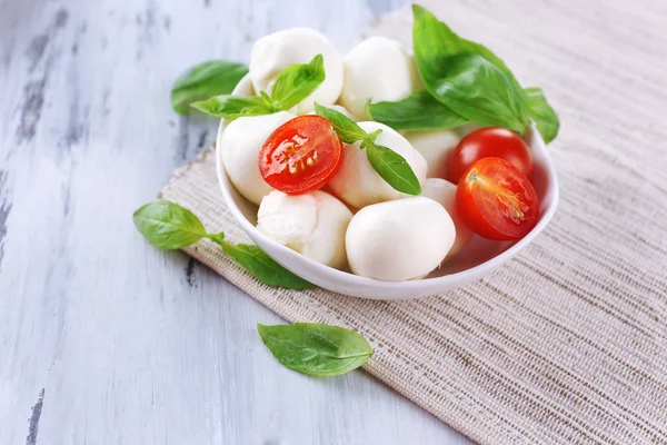 kase, ahşap masa üstünde domates ve fesleğen ile lezzetli mozzarella peyniri