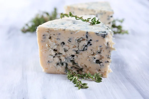 Smakelijke blauwe kaas met tijm op houten tafel — Stockfoto