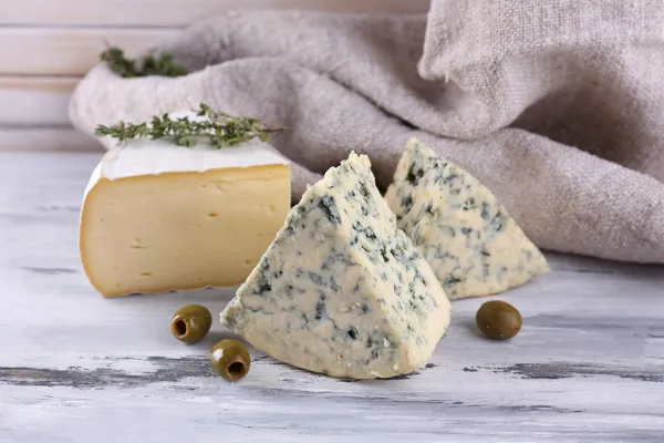Ahşap masa üzerinde farklı lezzetli peynir — Stok fotoğraf