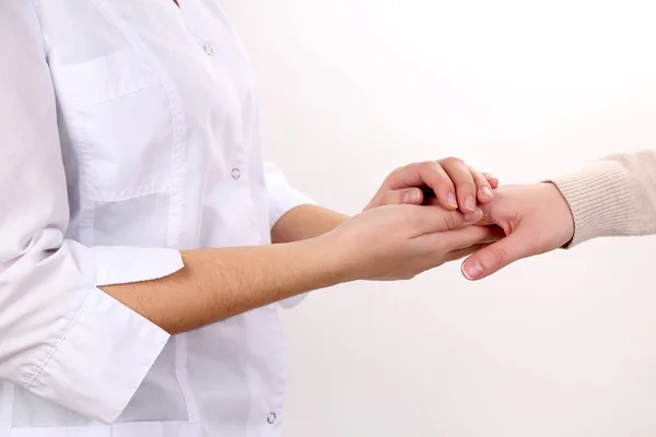 Ιατρός, κρατώντας το χέρι του ασθενούς, που απομονώνονται σε λευκό — Φωτογραφία Αρχείου