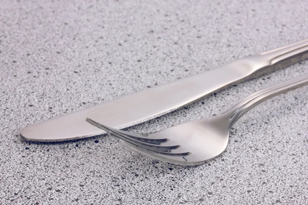 Forchetta e coltello sul tavolo di marmo — Foto Stock