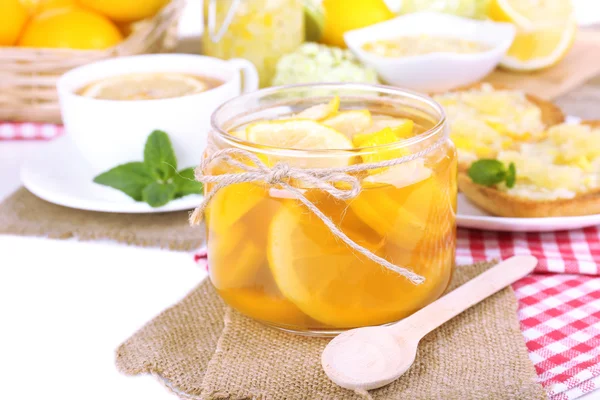 Tasty lemon jam with cup of tea on table close-up — Stock Photo, Image