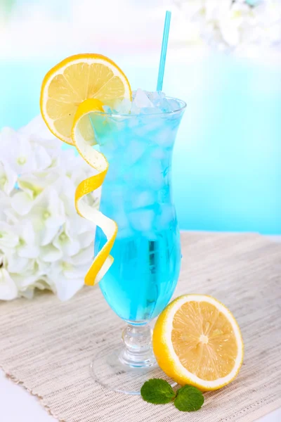 明るい青の背景上のテーブルにカクテルのグラス — ストック写真
