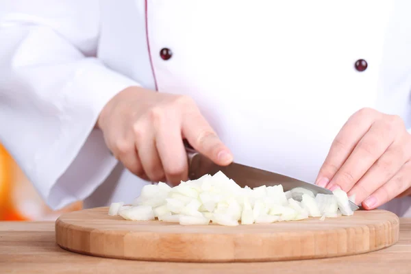 Female hands cutting bulb onion, on kitchen background — Stock Photo, Image