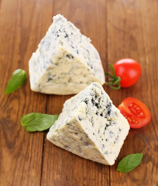 Smakelijke blauwe kaas met basilicum en tomaat, op houten tafel — Stockfoto