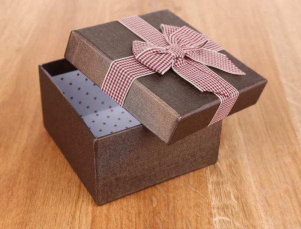 Открыть подарочную коробку на деревянном фоне — стоковое фото