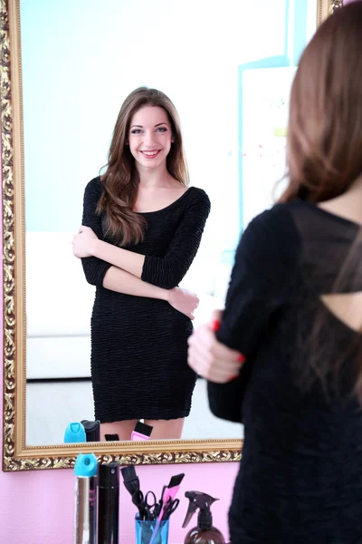 Jeune belle femme debout devant le miroir dans la chambre — Photo