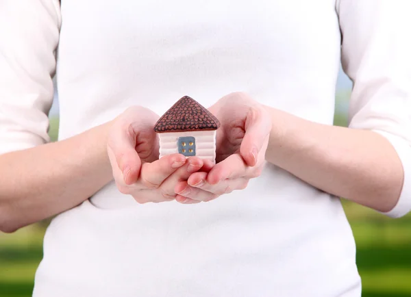 Little paper house in hand close-up, on bright background — Stock Photo, Image