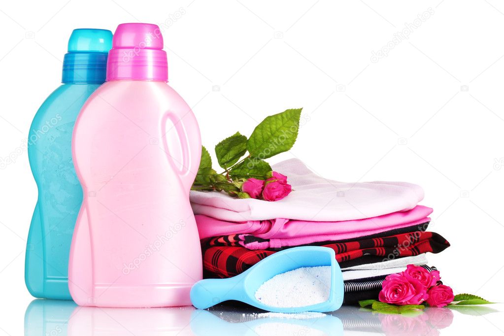 Detergent with washing powder and pile of colorful clothes isolated on
