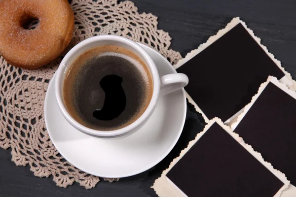 Tazza di caffè, ciambella e vecchie foto in bianco, su sfondo di legno — Foto Stock