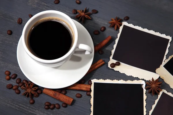 Koffiekopje en oude leeg foto's en specerijen, op houten achtergrond — Stockfoto