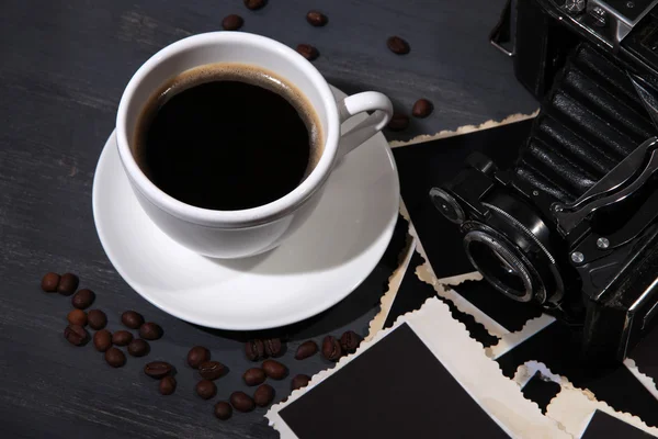 Taza de café y viejas fotos en blanco, sobre fondo de madera — Foto de Stock