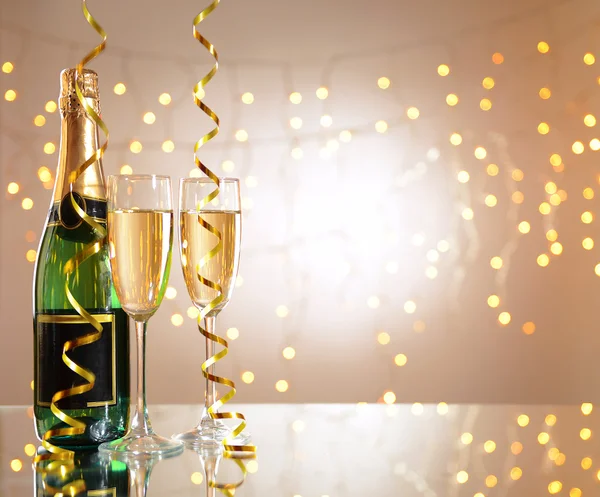 Glasses and bottle of champagne on shiny background — Stock Photo, Image