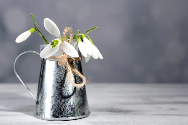 Vacker bukett av snödroppar i vas på ljus bakgrund — Stockfoto