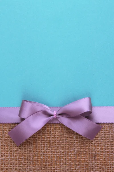 Sacktuch mit Farbband und Schleife auf farbigem Papier Hintergrund — Stockfoto