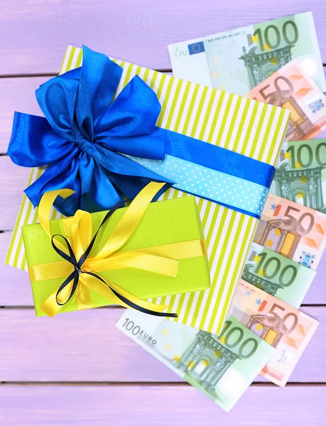 Caja de regalo con dinero en color fondo de madera —  Fotos de Stock