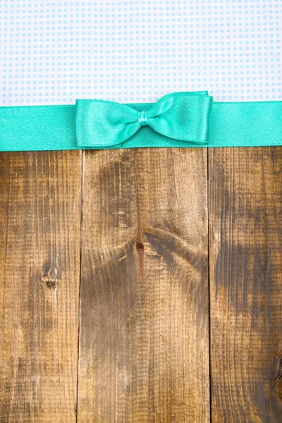 Барвиста тканина з кольоровою стрічкою та бантом на дерев'яному фоні — стокове фото