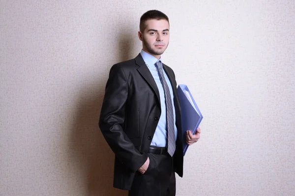 Portret van zakenman met map in de buurt van muur — Stockfoto