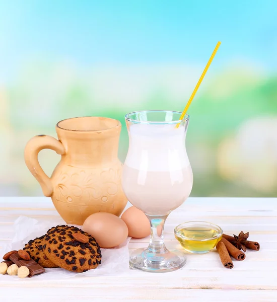 Eggnog with milk and eggs on wooden table and natural background — Stock Photo, Image