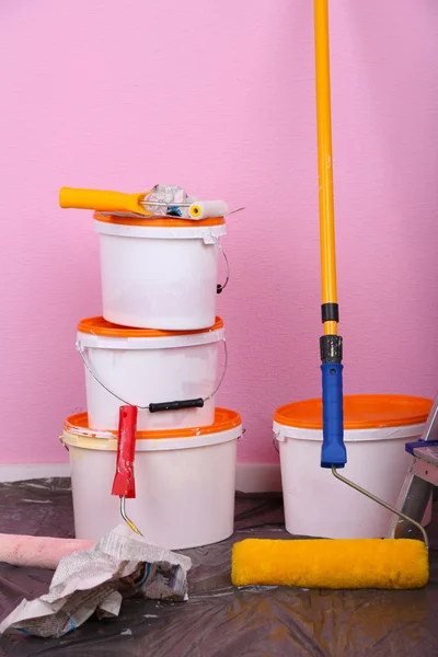 Cubos con pintura y escalera sobre fondo de pared. Foto conceptual de los trabajos de reparación en la habitación — Foto de Stock