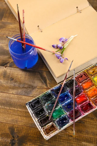 用彩色水彩、 刷子和木制的背景上的草绘器的组成 — 图库照片