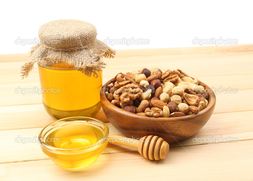 Sweet honey and different nuts on wooden table