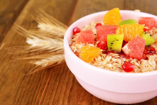 Deliciosa harina de avena con fruta en tazón en primer plano de la mesa —  Fotos de Stock