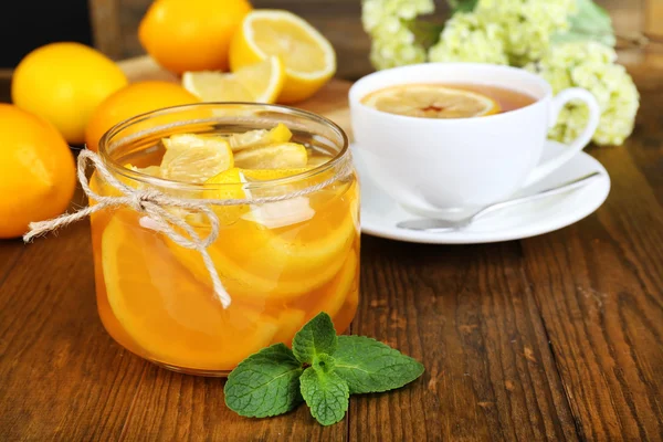 Leckere Zitronenmarmelade mit einer Tasse Tee auf dem Tisch in Großaufnahme — Stockfoto