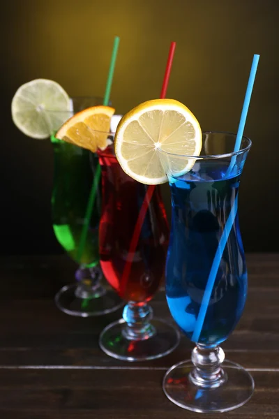 Glazen cocktails op tabel op donkere gele achtergrond — Stockfoto