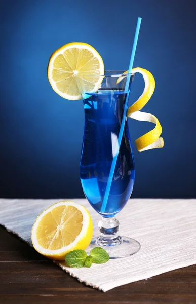 Bicchiere di cocktail sul tavolo su sfondo blu scuro — Foto Stock