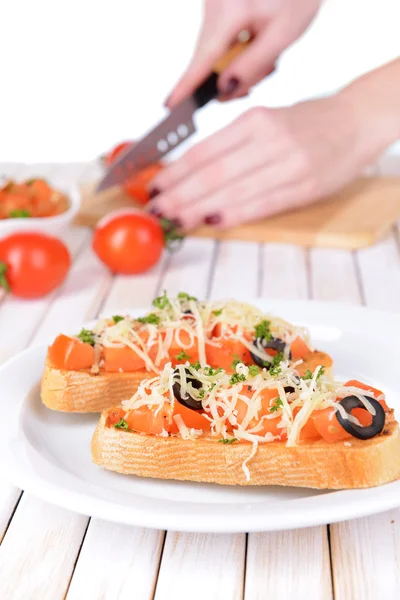 Pyszne bruschetta z pomidorami na tabliczce na stół szczegół — Zdjęcie stockowe