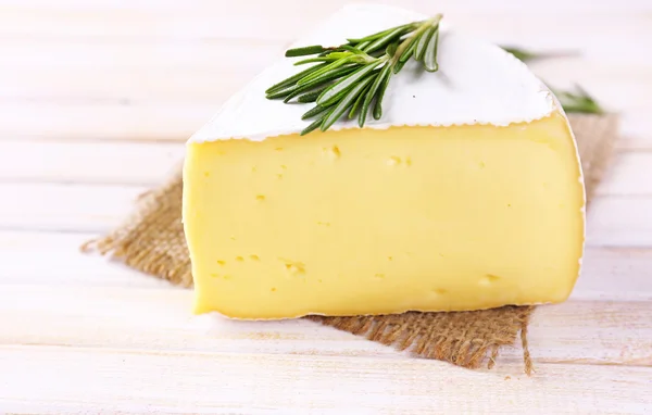 Gustoso formaggio Camembert con rosmarino, su tavola di legno — Foto Stock