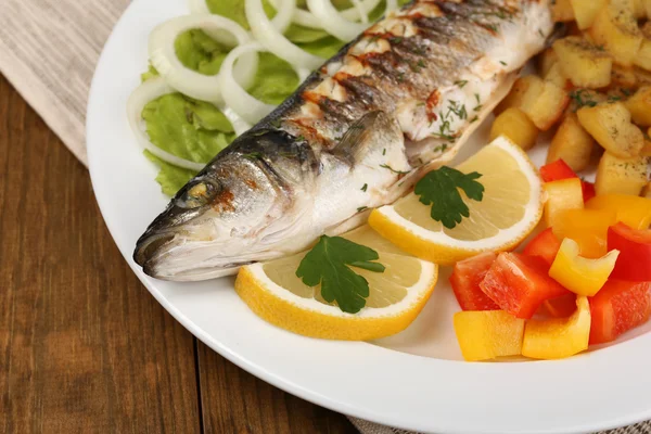 Вкусная рыба-гриль на тарелке на столе крупным планом — стоковое фото