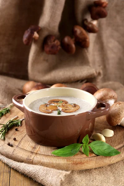 Mushroom soup in pot, on napkin,  on wooden background — Stock Photo, Image