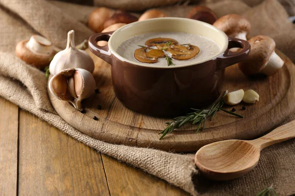 Composição com sopa de cogumelos em panela, cogumelos frescos e secos, na mesa de madeira, no fundo de pano de saco — Fotografia de Stock