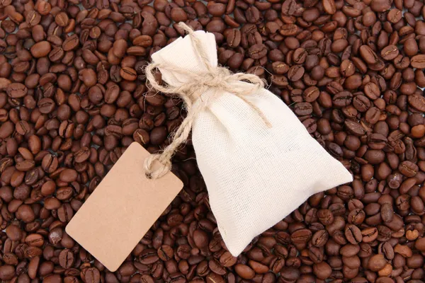 Worek z kawy na tle ziaren kawy — Zdjęcie stockowe