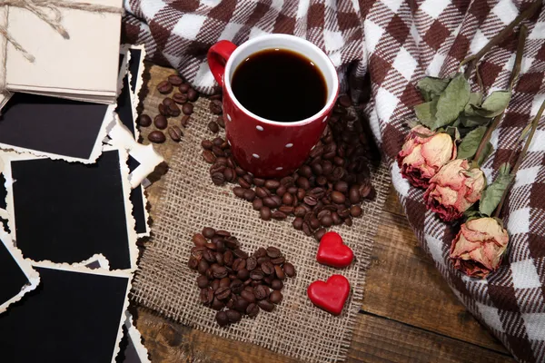 Composición con taza de café, corazones decorativos, especias a cuadros y viejas fotos en blanco, sobre fondo de madera —  Fotos de Stock