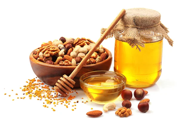 Zoete honing en verschillende noten, geïsoleerd op wit — Stockfoto