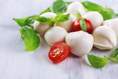 ahşap masa üstünde domates ve fesleğen ile lezzetli mozzarella peyniri