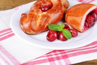 Tablo yakın çekim tabağa kiraz ile taze pişmiş pasties