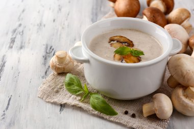 peçeteye ahşap arka plan üzerinde beyaz tencerede mantar çorbası