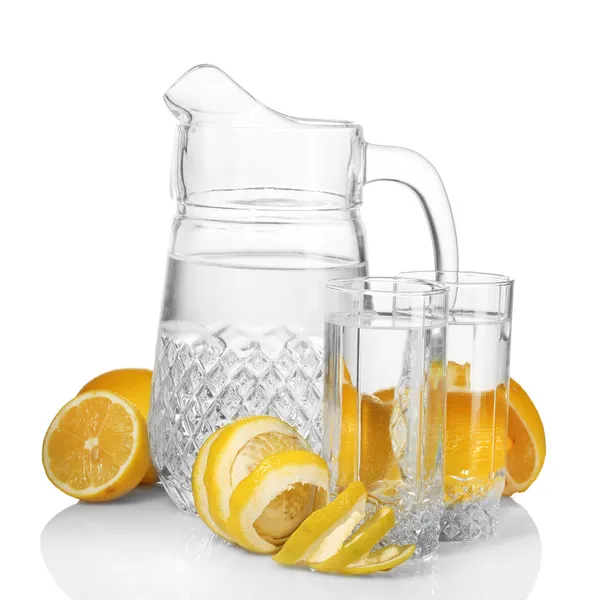 Pitcher and glasses of lemonade and lemon isolated on white — Stock Photo, Image