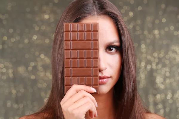 Retrato de menina bonita com chocolate no fundo brilhante — Fotografia de Stock