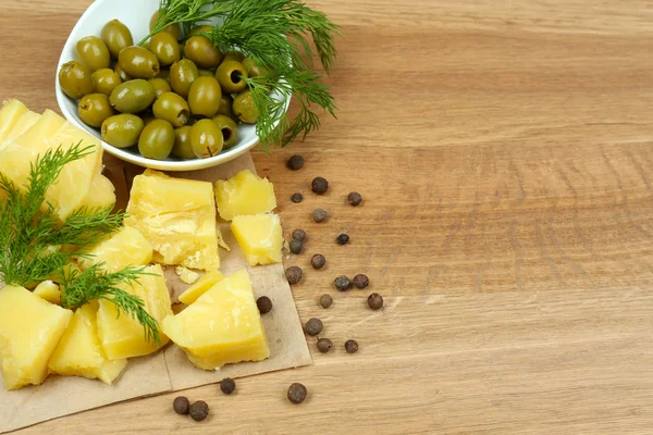 Queso parmesano, hierbas frescas y aceitunas sobre fondo de madera — Foto de Stock