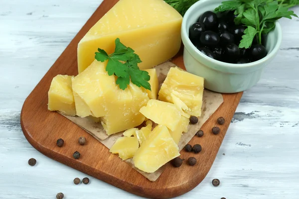 Parmesan cheese, fresh herbs and olives on wooden background — Stock Photo, Image