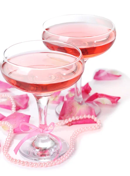 Composición con vino espumoso rosa en copas y pétalos de rosa aislados en blanco — Foto de Stock