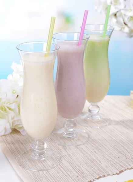 Melk schudt op tafel op lichte blauwe achtergrond — Stockfoto