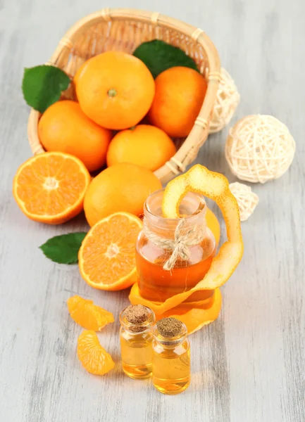 Tangerine essential oil and tangerines on wooden table — Stock Photo, Image