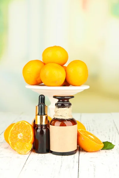 Tangerine essential oil and tangerines on wooden table — Stock Photo, Image
